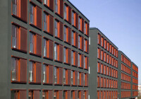 Markant: hinterlüftete Putzfassade in Rot und Schwarz