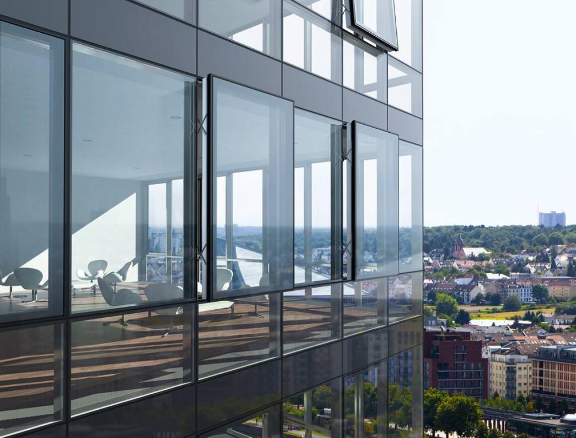 Fassadenansicht der Schüco Structural-Glazing-Fassade FW 50+ SG.SI mit nach außen öffnenden Senkklapp- und Parallel-Ausstell-Flügeln der Fensterserie AWS 114.