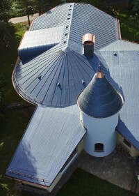 Mit vielen Neigungen versehenes Villendach mit Evalon-Flachdachbahnen schick saniert