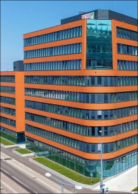 Kontrapunkt zum verklinkerten Gasometer: in lachsfarbenes Argeton gehülltes Bürogebäude